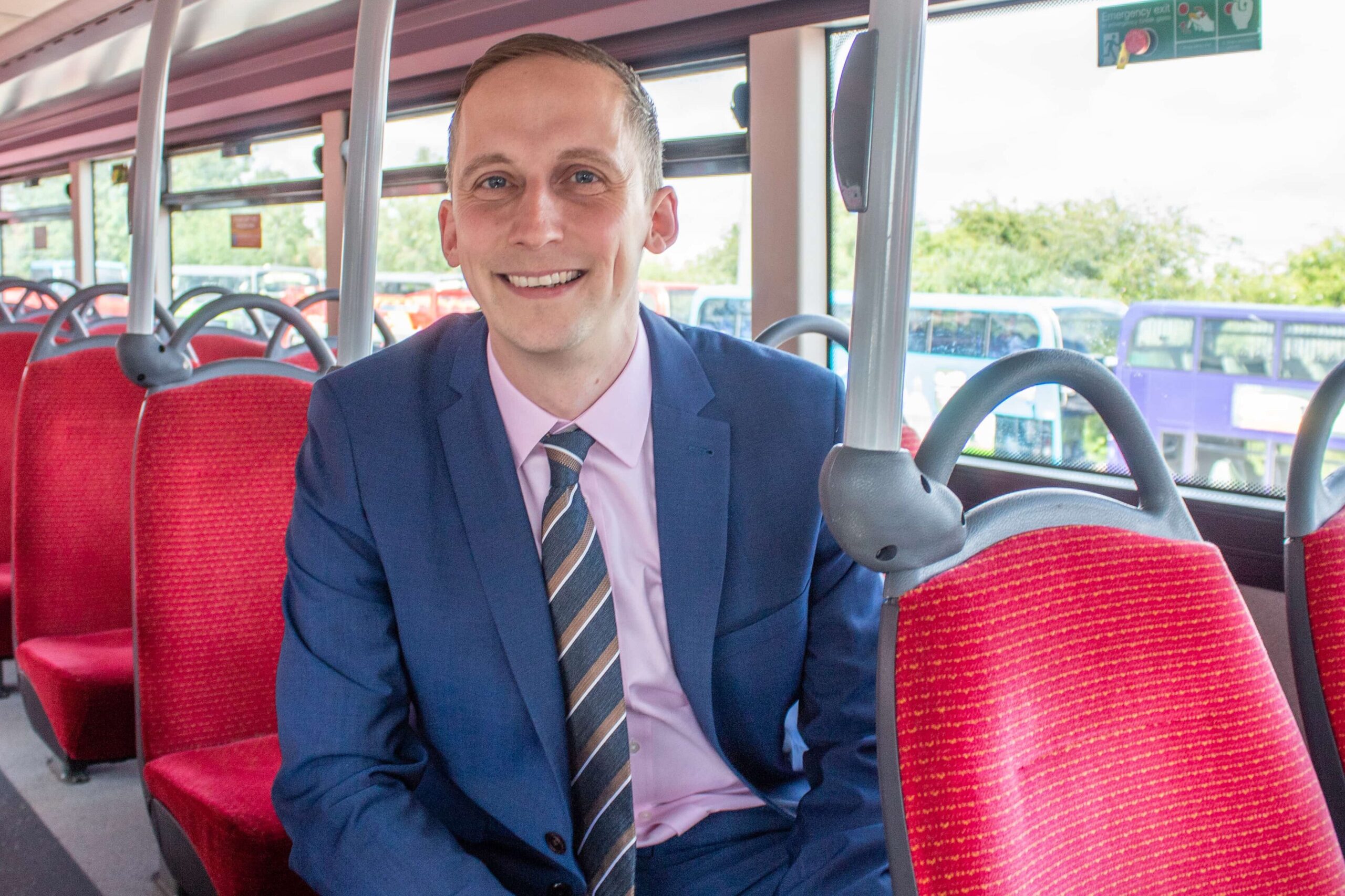 Luke Marion, MD of carousel buses sat on a bus with red seats